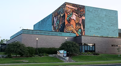 The Bloomington Civic Plaza featuring a large, colorful modern art mural on the building exterior.